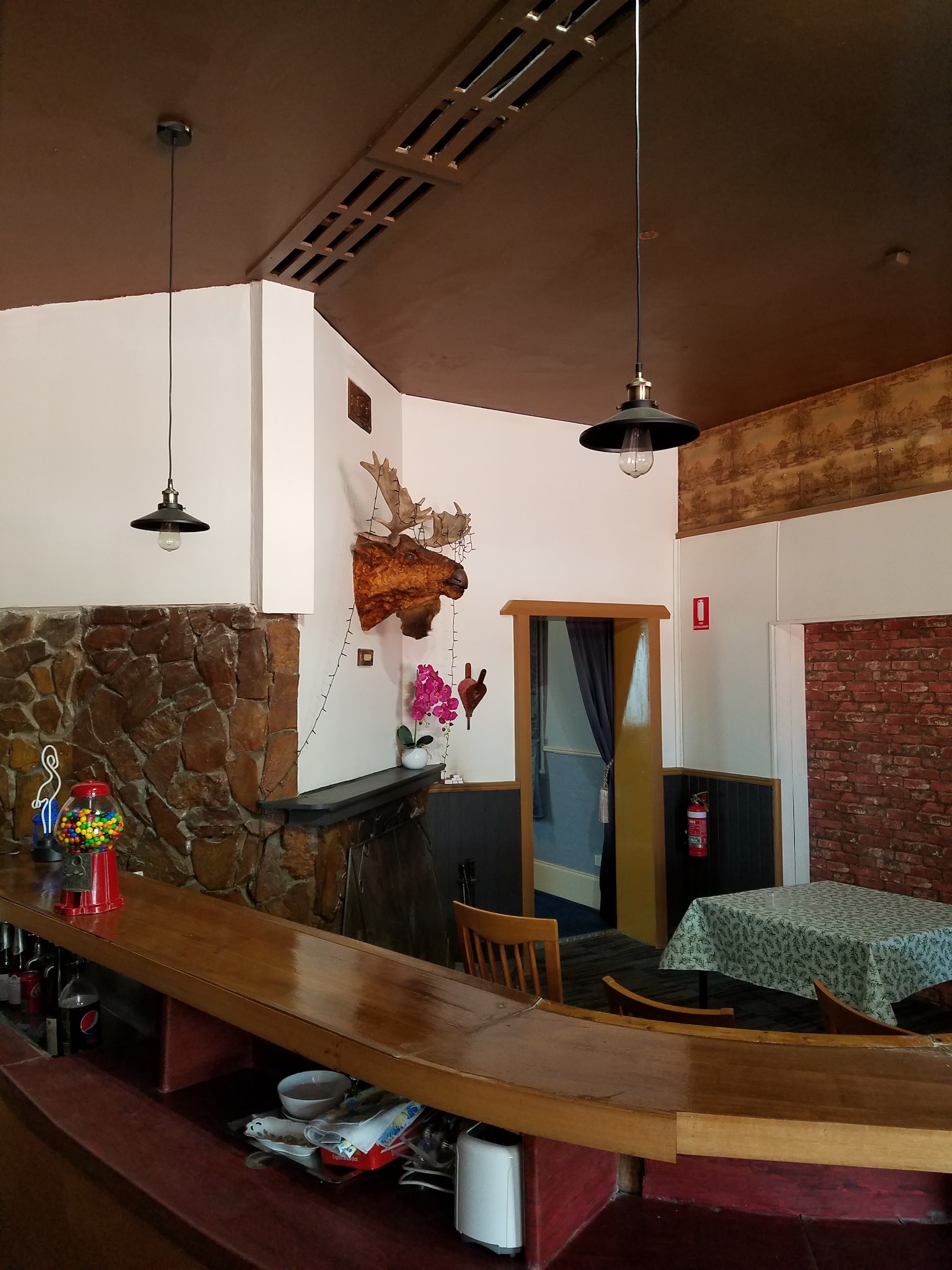 The long timber bar inside the hotel, with a stone wall and high raked ceiling