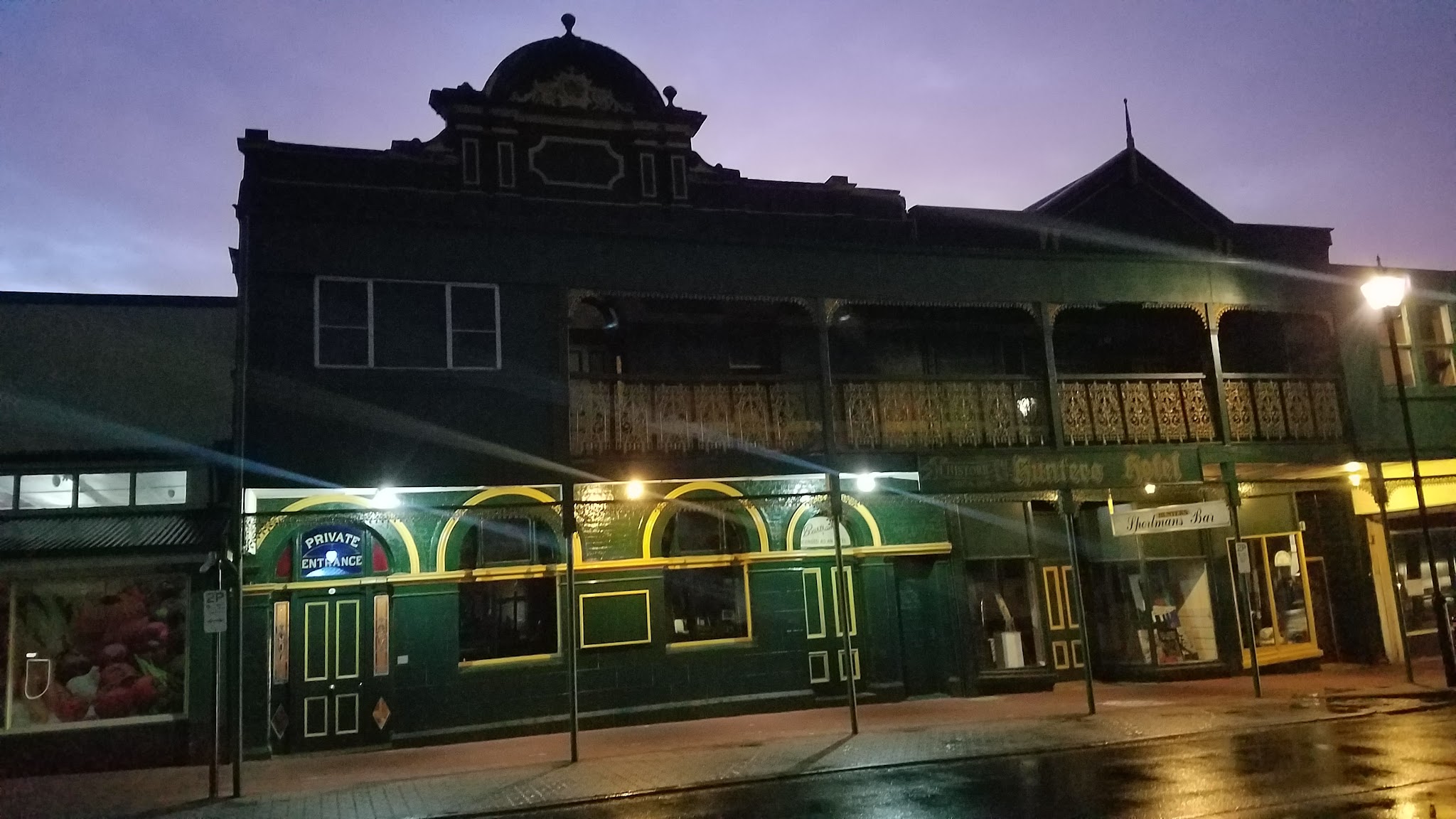 The hotel lit up at dusk under a purple sky after rain